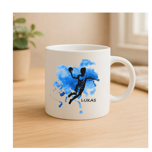 Personalisierte Keramiktasse mit Handballer-Motiv, Schwarz-Silhouette, Farbklecks-Hintergrund, beidseitig bedruckt, personalisierbar für Kinder, Jugendliche & Erwachsene